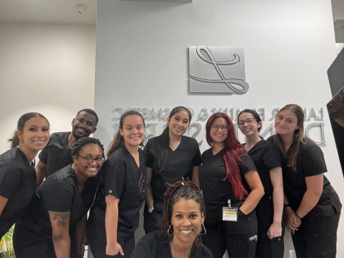 group of dental assistant students smiling in dentist office